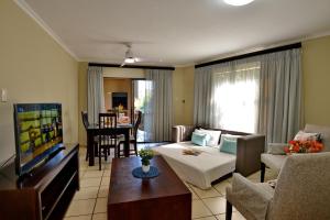 a living room with a couch and a tv at Uvongo River Resort by MyResorts in Margate