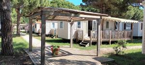 a cabin with a canopy and a fire hydrant on a deck at Mobilhome 217 in Torreilles