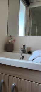 a bathroom counter with a sink and a mirror at Mobilhome 217 in Torreilles +17 photos