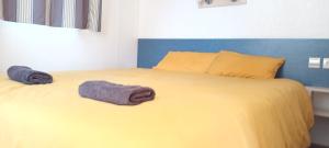 a yellow bed with two towels on top of it at Mobilhome 217 in Torreilles