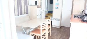 a small kitchen with a table and chairs in a room at Mobilhome 217 in Torreilles