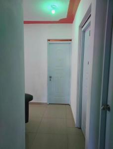 a hallway with a blue door and a white wall at BAYO-HOTEl in Vaudreuil