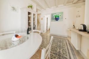 a dining room with a white table and chairs at Antico Mondo Rooms & Suites in Polignano a Mare +273 photos