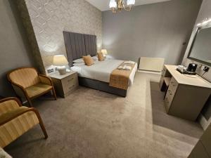 a bedroom with a bed and a desk and a television at Bedford Hotel in Lytham St Annes