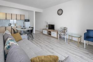 a living room with a couch and a table and a kitchen at White Cove Apartments in Lokva Rogoznica
