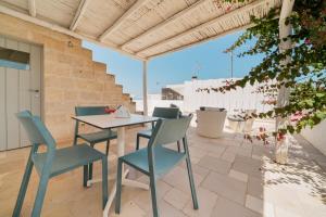 a table and chairs on a patio with a view at Antico Mondo Rooms & Suites in Polignano a Mare
