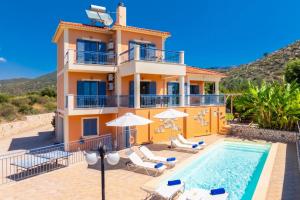 a villa with a swimming pool and a house at Villa Xenia in Karavádhos
