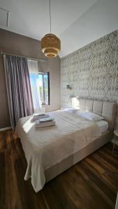a bedroom with a large white bed with a window at Villa Lazarina Vineyard Views in Kvareli