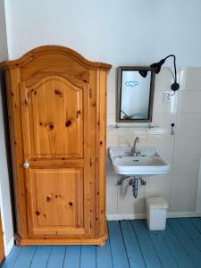 a bathroom with a wooden cabinet and a sink at Hostel Burg Hausen in Heimbach