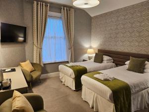 a hotel room with two beds and a tv at Bedford Hotel in Lytham St Annes +56 photos