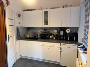 a white kitchen with white cabinets and appliances at Żagiel 3 in Pobierowo