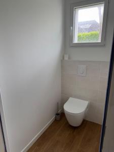 a bathroom with a toilet and a window at Studio indépendant à notre maison in Concarneau