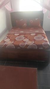 a bed with a wooden frame with a design on it at FG Bungalow Bar in Ianakandrarezo +1 photo