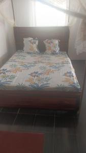 a bed with a blanket on it with a window at FG Bungalow Bar in Ianakandrarezo