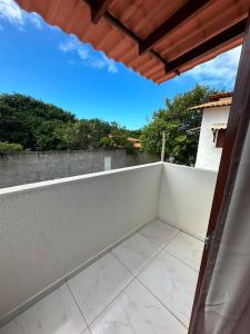 a balcony with a white fence and trees at Casa Flora & Mar in Pipa