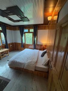 a bedroom with a large bed in a house at Gaunnie Valley - Jibhi in Jibhi