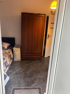 a bedroom with a wooden cabinet next to a bed at Żagiel 3 in Pobierowo
