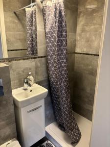 a bathroom with a sink and a shower curtain at Żagiel 3 in Pobierowo