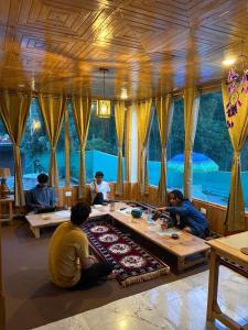 a group of people sitting around a table in a room at Gaunnie Valley - Jibhi in Jibhi