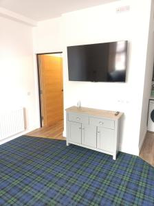 a living room with a flat screen tv on a wall at The Townhouse Self Catering in Dumfries