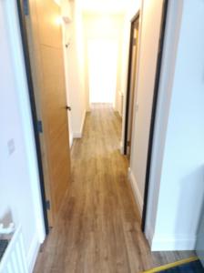 a hallway of an apartment with a wooden floor at The Townhouse Self Catering in Dumfries