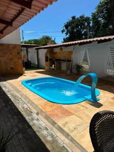 a swimming pool with a water fountain in a yard at Casa Flora & Mar in Pipa