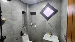 a bathroom with a sink and a toilet and a window at Bungalow in Tangier in Tangier