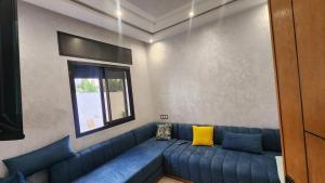 a blue couch in a living room with a window at Bungalow in Tangier in Tangier