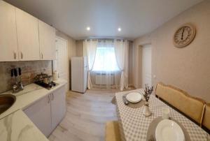 eine Küche mit einem Tisch und einem Kühlschrank in der Unterkunft Rest 33 in Odessa