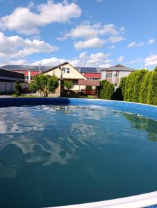 a large blue swimming pool in front of a house at Гостьовий будинок з банею in Bohuslav