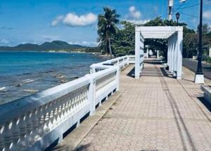 a walkway next to the ocean with a white canopy at Pilot Glamp in Vieques