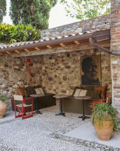 a patio with couches and a portrait of a man at Locanda Hemingway in Bassano del Grappa