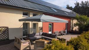 a patio with a couch and an umbrella at FitnessFun in Krzyż