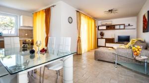 a kitchen and living room with a glass counter top at Mare & Mons Seafront Apartments in Malinska