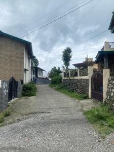 an empty street next to a brick building at Pahari Trekkers in Nainital +3 photos