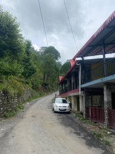 a white car parked on the side of a dirt road at Pahari Trekkers in Nainital