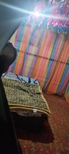 a bed sitting in a room with a colorful wall at eco friendly camping site pahalgam in Pahalgām +9 photos