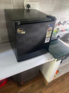 a refrigerator sitting on a shelf in a kitchen at Pahari Trekkers in Nainital