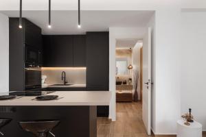 a kitchen with black cabinets and a white counter top at Vouliagmeni Olivomare Suite in Athens