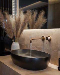 a black bowl sink with a faucet in a bathroom at Vouliagmeni Olivomare Suite in Athens +3 photos