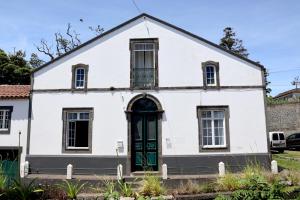 an old white house with a green door at Recanto do Capucho in Conceição