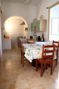 a kitchen with a table and chairs and a kitchen with green cabinets at Recanto do Capucho in Conceição