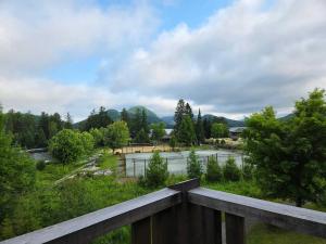 a view of a river from a wooden balcony at Condo by the Lake - Mountain View & Resort in Lac-Superieur