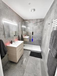 a bathroom with a white sink and a shower at Rochetaillée Secret Spa in Saint-Étienne +5 photos