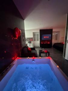 a large tub in a living room with a tv at Rochetaillée Secret Spa in Saint-Étienne