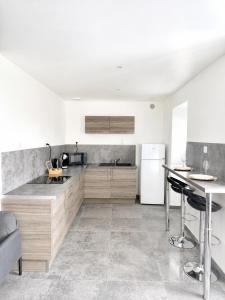 a kitchen with wooden cabinets and a white refrigerator at Rochetaillée Secret Spa in Saint-Étienne