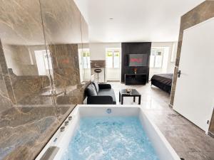 a large bath tub in a living room with a couch at Rochetaillée Secret Spa in Saint-Étienne