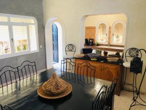 a kitchen with a table with chairs and a tableasteryasteryasteryasteryasteryastery at Villa Azal in Mirleft
