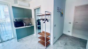 a kitchen with green cabinets and a wooden shelf at Casa di Bea 2 in Ventimiglia +1 photo