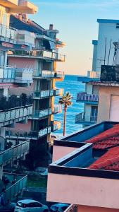 a tall building with a palm tree next to the ocean at Casa di Bea 2 in Ventimiglia